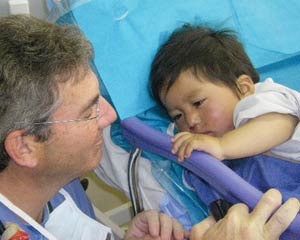 Brad Jubelirer, MD, with cleft palate patient in PACU.