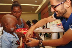 Dr. Shrime examining a young boy with burn contractures. (Courtesy Mercy Ships, International)