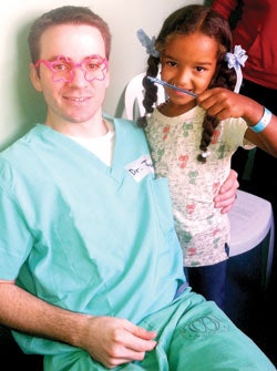 Jordan L. Wallin, MD, in the HanesBrands Mobile Clinic with a beautiful child with severe burns.