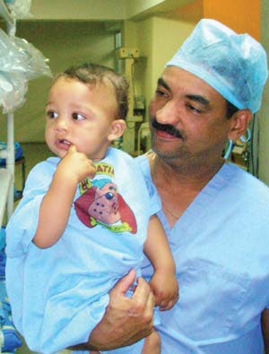 Dr. Batista escorts a patient undergoing cleft palate repair to the operating room.