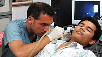 Anthony Del Signore, MD, examines a patient’s ear during the screening clinic.