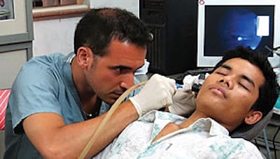 Anthony Del Signore, MD, examines a patient’s ear during the screening clinic.