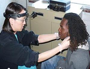 ENT resident Dr. Elina Kari (left) examines a patient during a head and neck cancer evaluation at the HEALing Community Center at City of Refuge.