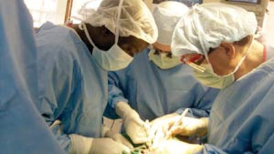 Dr. Henry Ngoitsi of MTRH (left), Dr. Edward Weisberger of IUSM (right), and Dr. Moberly (middle) perform a thyroidectomy on a patient with a large goiter.