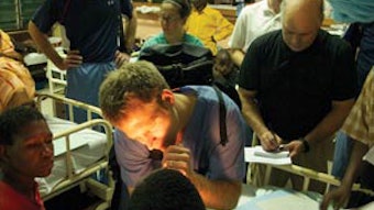 Dr. Mangus examines a child with a cleft lip while rounding with Dr. Netterville and Dr. Sinard.