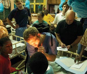 Dr. Mangus examines a child with a cleft lip while rounding with Dr. Netterville and Dr. Sinard.