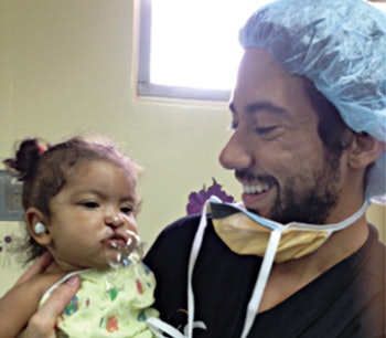 Pediatric anesthesiologist Jairo Castillo, MD, (left) and otolaryngology resident Neha Patel, MD, with patient prior to cleft lip repair.