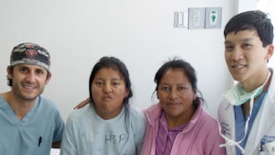 (L) Dr. Handler poses with a patient and mother in pre-op alongside Dr. Setabutr.