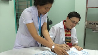 Dr. Brent Senior signs a large stack of paperwork for one of the nurses