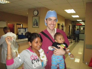 Stewart Adam, MD, with a patient and mother after cleft palate surgery.
