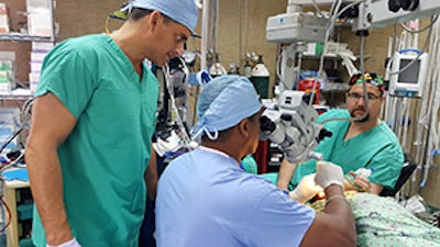 John Sinacori, MD, observes as Mauricio Loredo, MD, performs ear surgery. At right is anesthesiologist Matt Cecchini, MD.