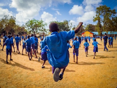 Figure 2. A child at the Gede Primary School celebrating after his school received several new soccer balls after completion of hearing screenings.