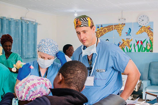 Two surgeons evaluating a patient.