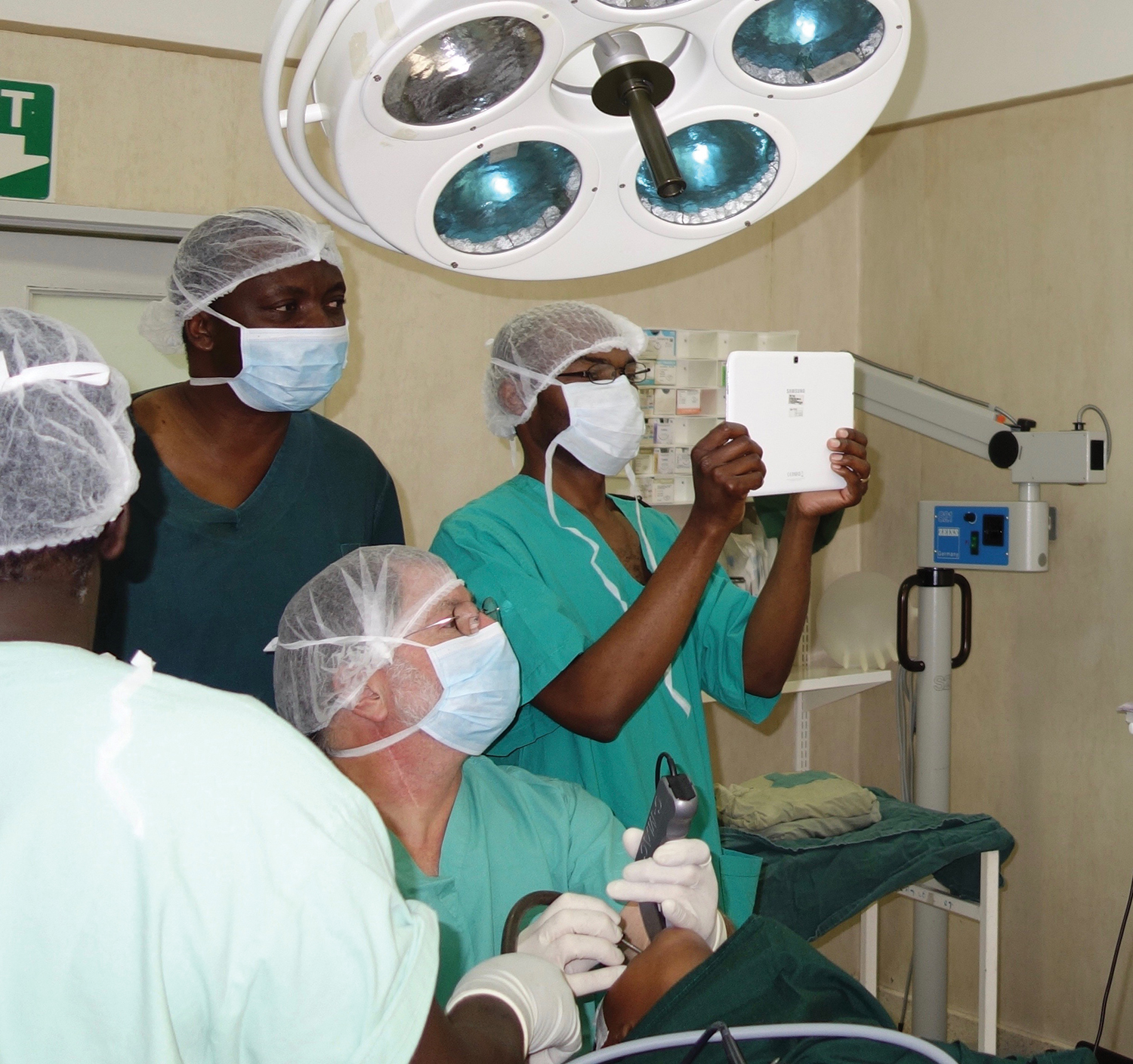Healthcare team examining a child in the operating room. Dr. Koltai (seated in center of the photo) is performing the laryngoscopy.