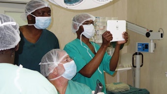 Healthcare team examining a child in the operating room. Dr. Koltai (seated in center of the photo) is performing the laryngoscopy.