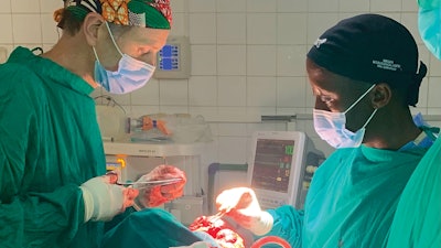 David A. Shaye, MD, (left) and Victor Nyabyenda, MD, (right) jointly excise a maxillary tumor present for 12 years in a 53-year-old Rwandan man. The open approach permitted the exposure necessary to completely excise the tumor, and reconstruction was performed with a temporalis muscle flap.