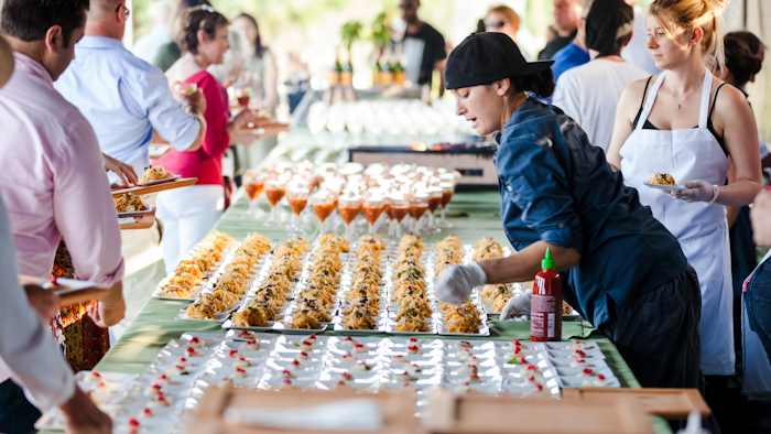 Meeting attendees line up for starters at Swank Specialty Produce, which offers farm-fresh ingredients.