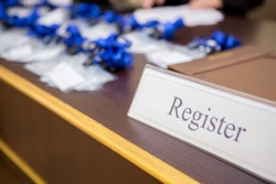 Image of registration desk with badges and sign