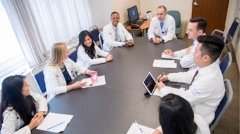 Group of medical professionals seated around a conference table.