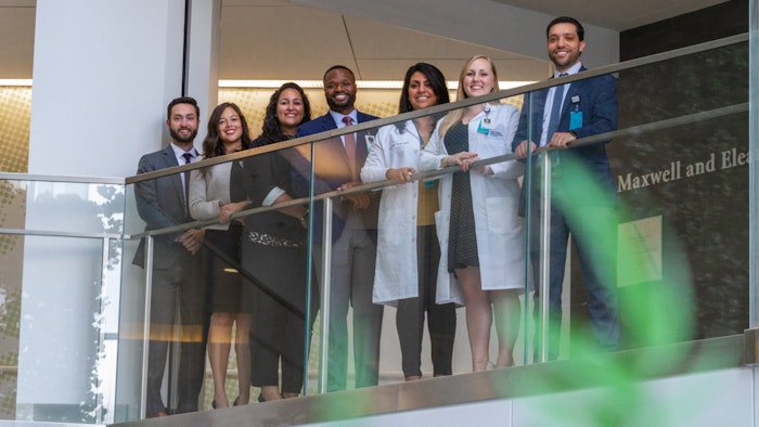 Photo of seven medical professionals standing behind a railing.