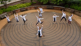 Photo of doctors in lab coats jumping in the air