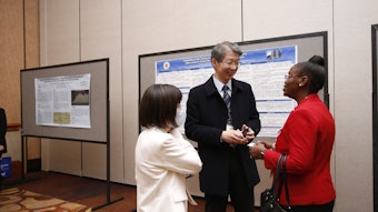 Toyin Tofade (right) confers with poster presenter Yuh Lin (center)