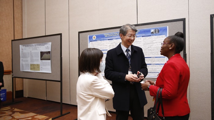 Toyin Tofade (right) confers with poster presenter Yuh Lin (center)