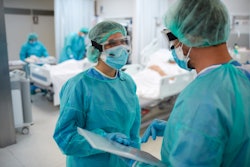 Two healthcare workers talking at the UCI - stock photo