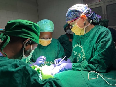 Dr. Sebelik operating on a patient with a large goiter while teaching Rwandan medical students