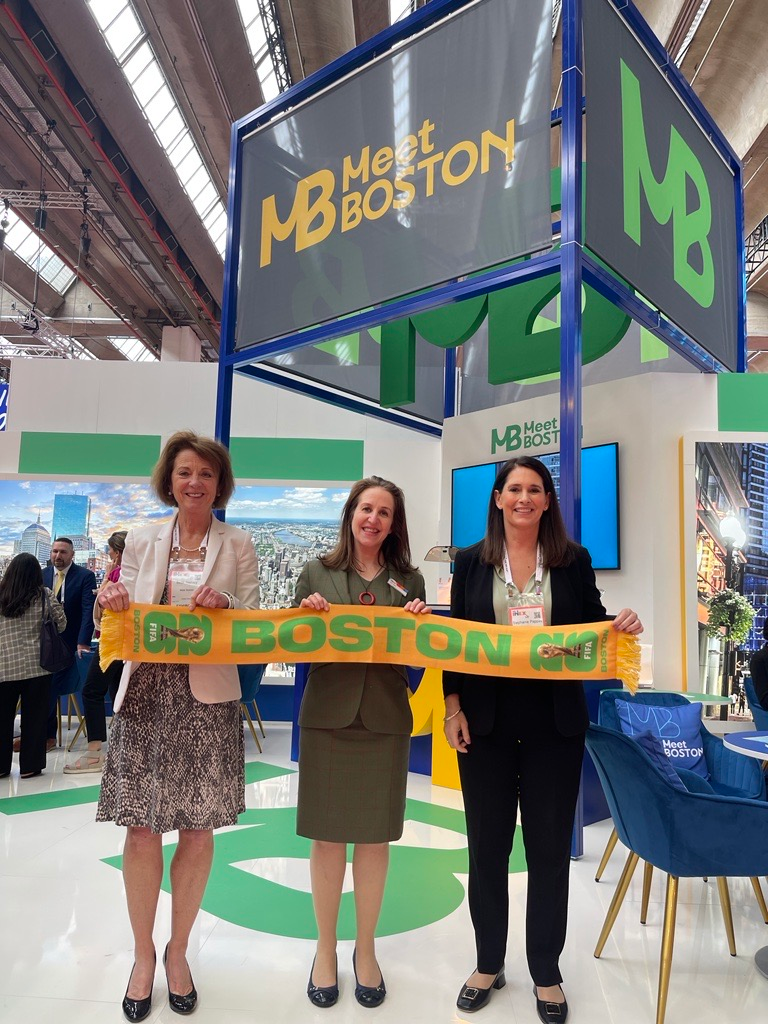 Carina Bauer, CEO, IMEX Group, receives one of the 100 scarves made to celebrate Boston as the host city for the 2026 FIFA World Cup.
