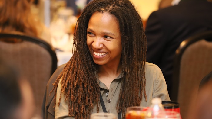 person smiling with group at table having food and drink
