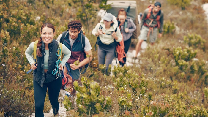 group of young adults smiling, enjoying hike