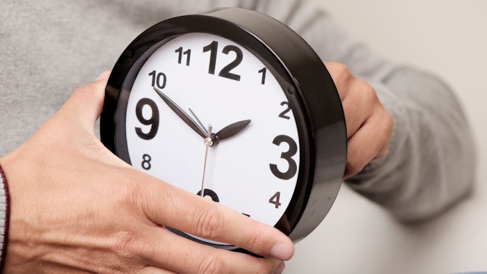 person winding clock forward an hour