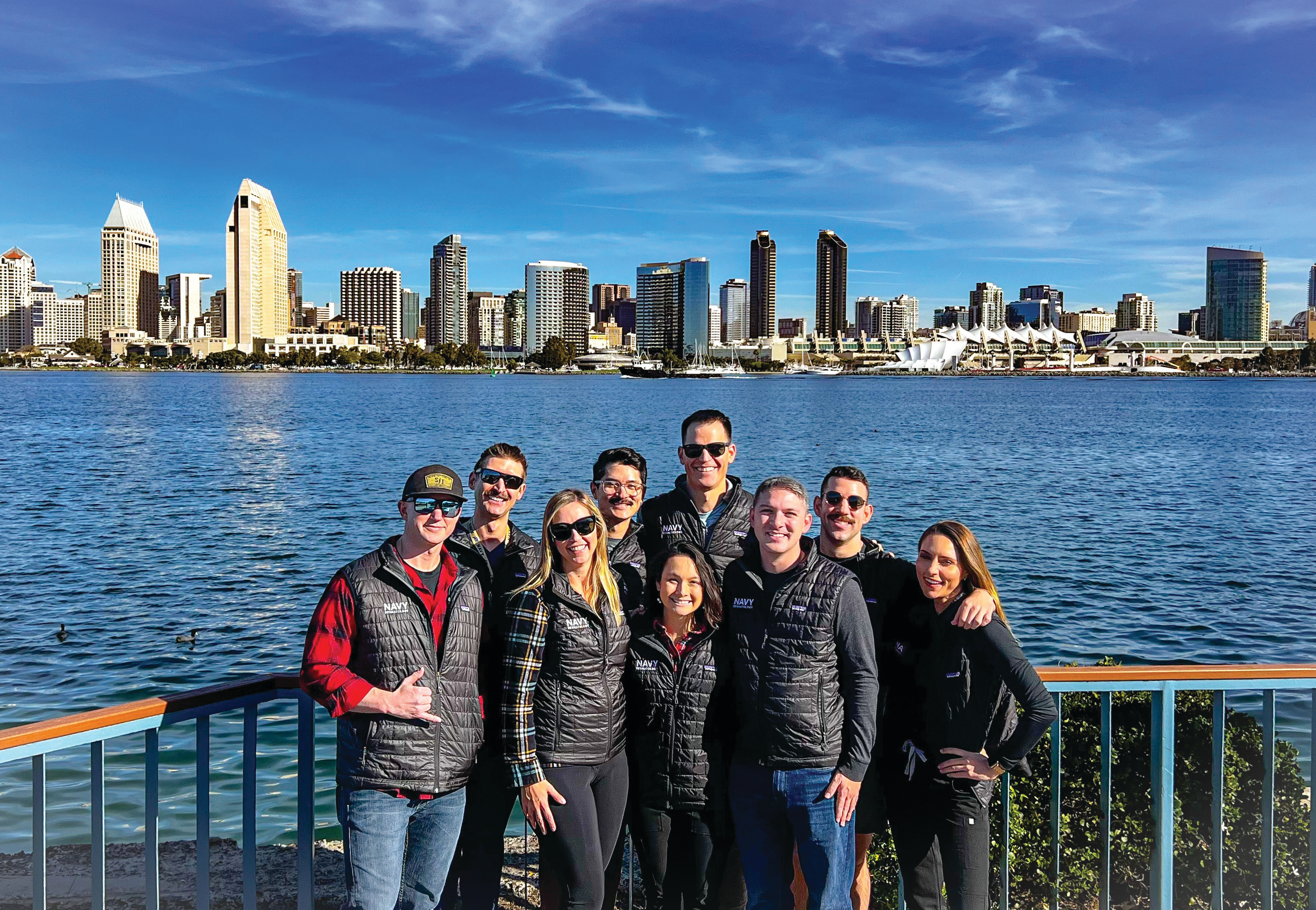 Group of local dermatology residents posing with San Diego skyline in background