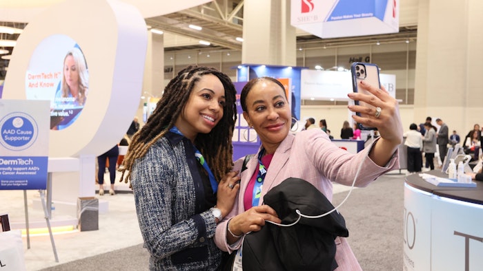 Two attendees taking selfie on exhibit floor