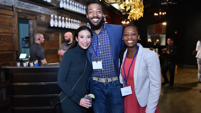 Three happy hour attendees smiling for camera