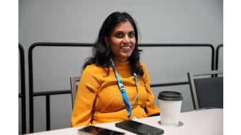 Anisha Patel sits at table.