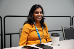 Anisha Patel sits at table.
