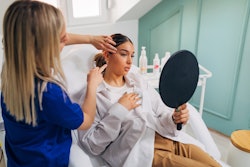 Dermatology associate preparing a woman's face for a cosmetic procedure.