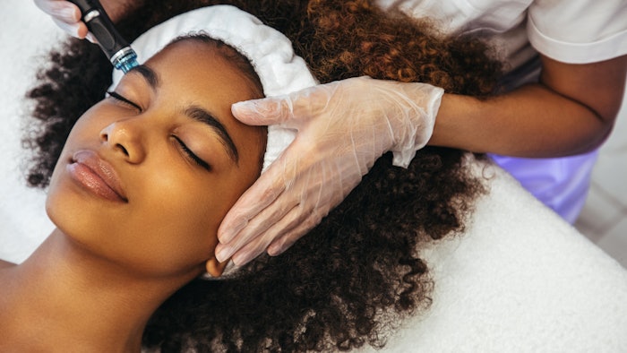 A Black woman is undergoing an aesthetic procedure.