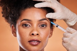 Young Black female patient gets botulinum toxin injection.