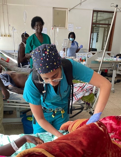 The author during morning rounds, changing dressings and teaching families about wound care.