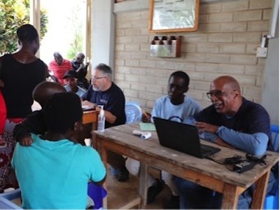 Orthopedic surgeon Clyde Henderson, MD (right), and the author with their language interpreters during patient intake in Roche Village, Tanzania.