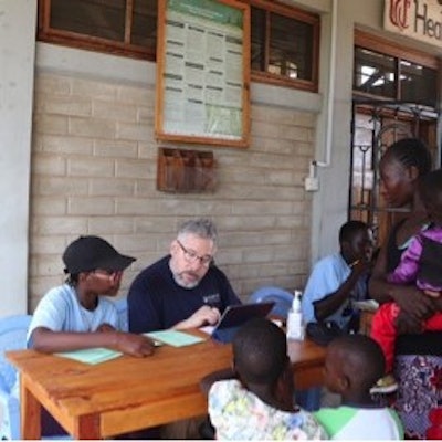 The author (middle) and an interpreter during patient intake at the UC Health clinic in Roche Village.