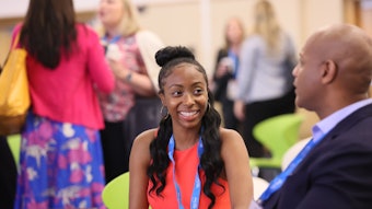 This is a photo of the 2023 AAD Innovation Academy with two Black professionals talking and smiling.