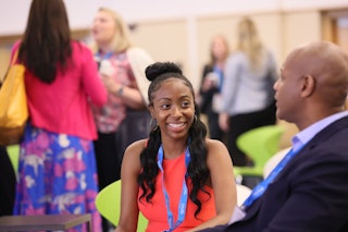 This is a photo of the 2023 AAD Innovation Academy with two Black professionals talking and smiling.
