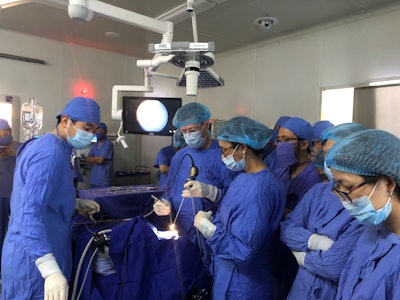 The author participating in on-site procedure with local physicians in Vietnam.