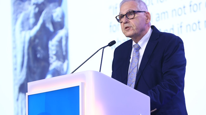 This is a photo of Warren R. Heymann, MD, FAAD standing at a podium and speaking at AAD Innovation Academy.