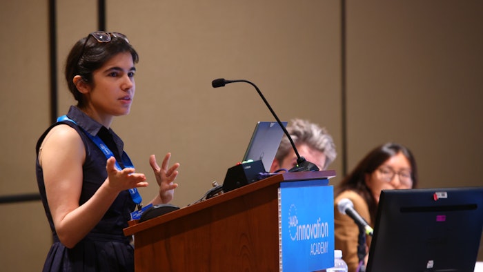 This is a photo of Fiorinda F. Muhaj, MD, FAAD standing at a podium and speaking at AAD Innovation Academy.