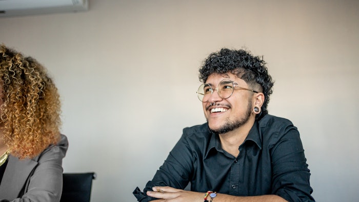 This is a photo of a smiling, transgender man.